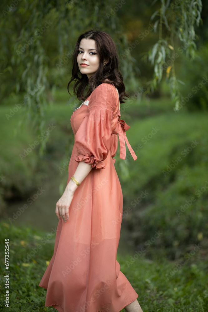 A beautiful model in a retro dress poses in the park, I swear it's green and beautiful weather. A beautiful model in a retro dress poses in the park, I swear it's green and beautiful weather.