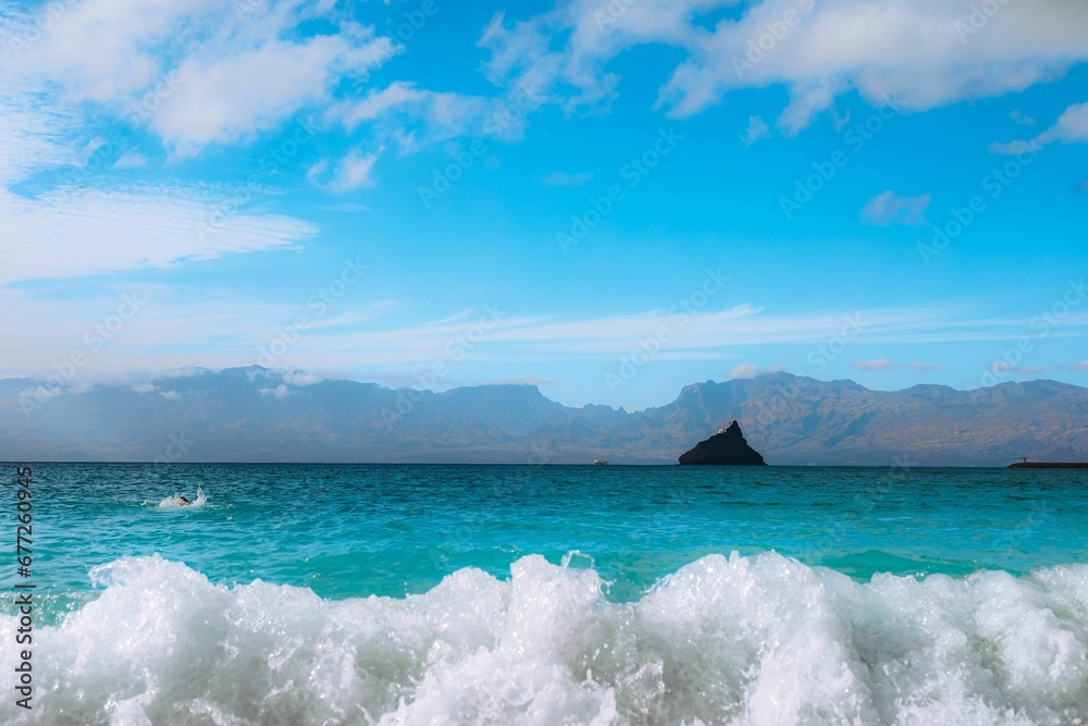 Beautiful view of turquoise sea with foamy waves under the blue sky