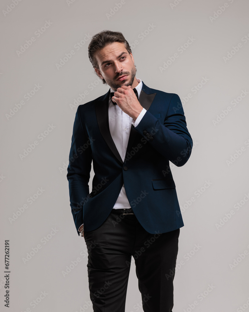 thoughtful businessman in tuxedo looking up side, touching chin and thinking thoughtful businessman in tuxedo looking up side, touching chin and thinking