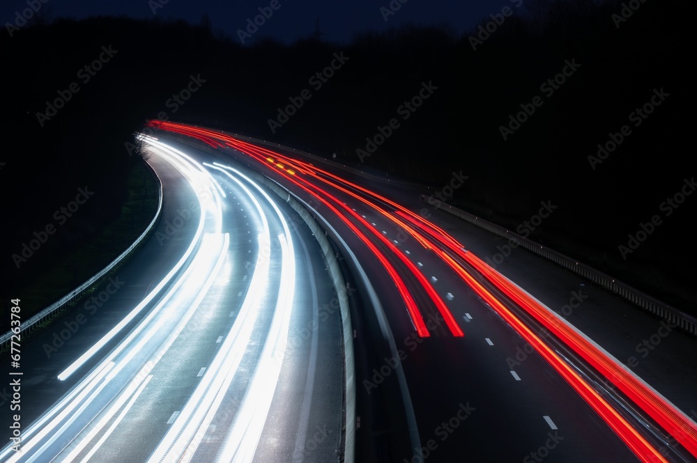 Aerial view of light trails of cars on a highway road at night