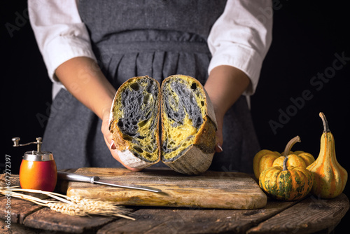 sourdough activated charcoal black bread with pumpkin turmeric and housewife woman baker rustic style