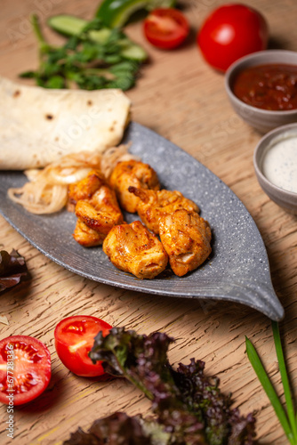 top view of a chicken kebab in a plate on a table in a restaurant