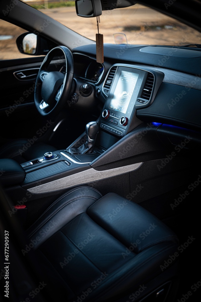 Close-up of the steering wheel, LCD radio, and gear shift lever in a car