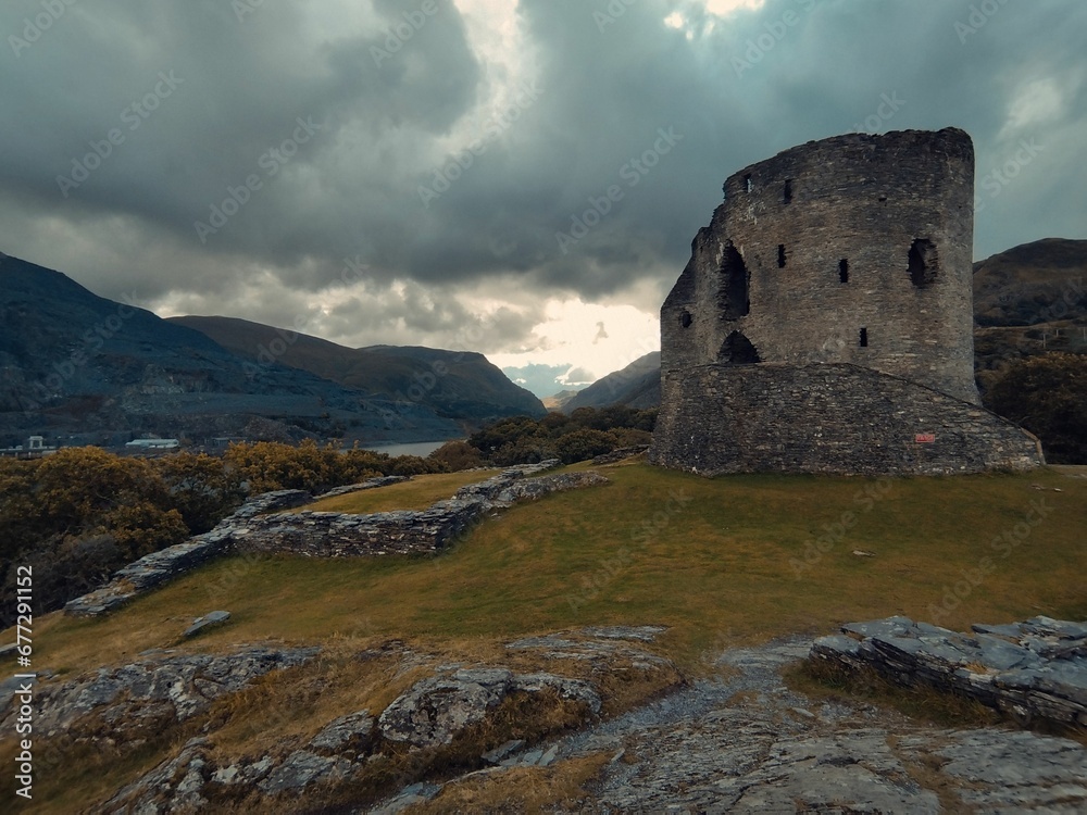 Breathtaking view of Dolbadarn Castle under dramatic cloudy sky in Wales