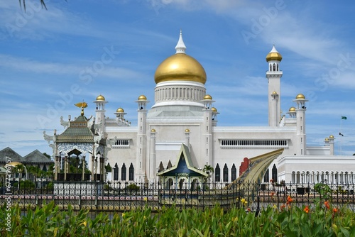 Exterior view of Omar Ali Saifuddien Mosque, Brunei, with a golden-domed roof and a metallic fence photo