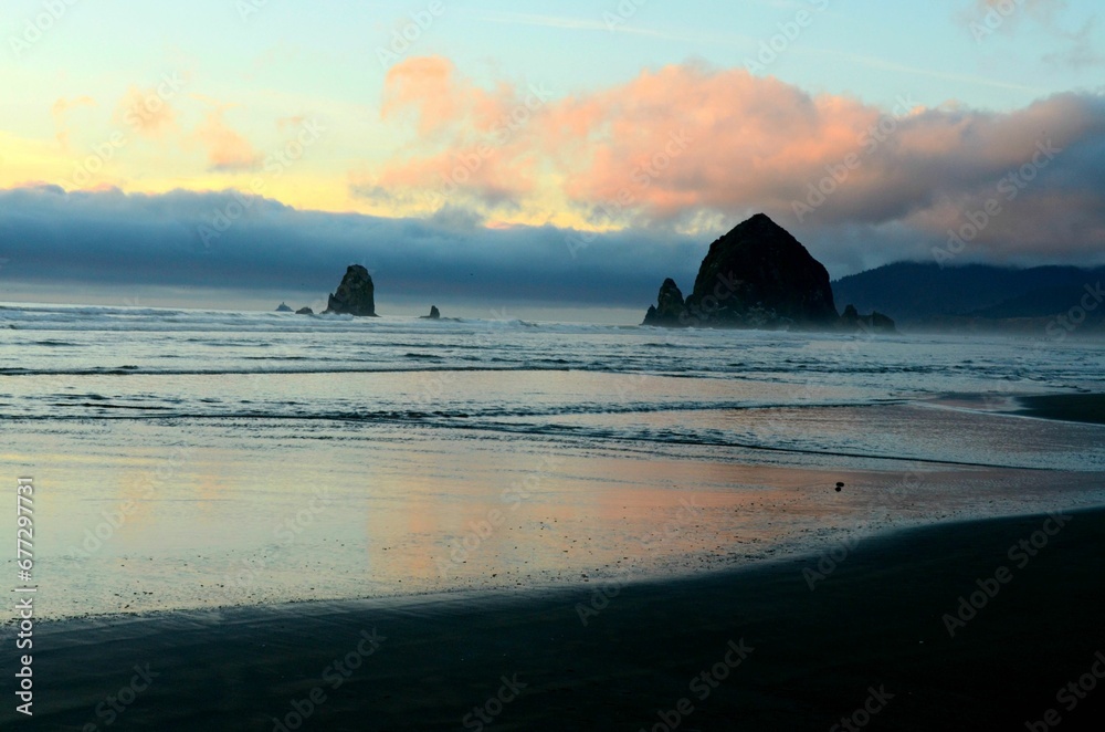 Skyline of Haystack rock at the Cannon beach captured against the cloudy sunset sky