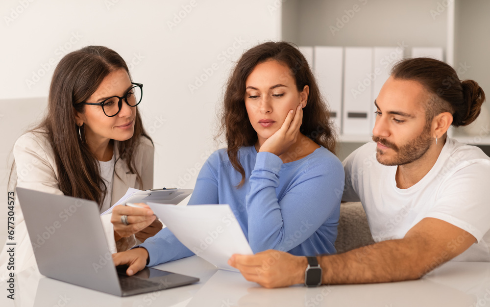 Joyful newlyweds pensive young european couple engage in property discussion Joyful newlyweds pensive young european couple engage in property discussion