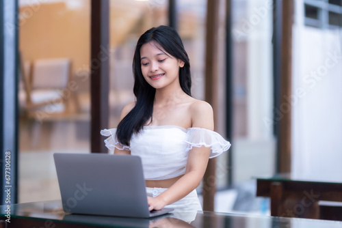 Portrait of asian freelance teenage people businesswoman casual working with laptop computer in cafe interior in coffee shop background,business expressed confidence embolden and successful concept