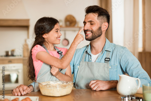 Playful baking moment between dad and child