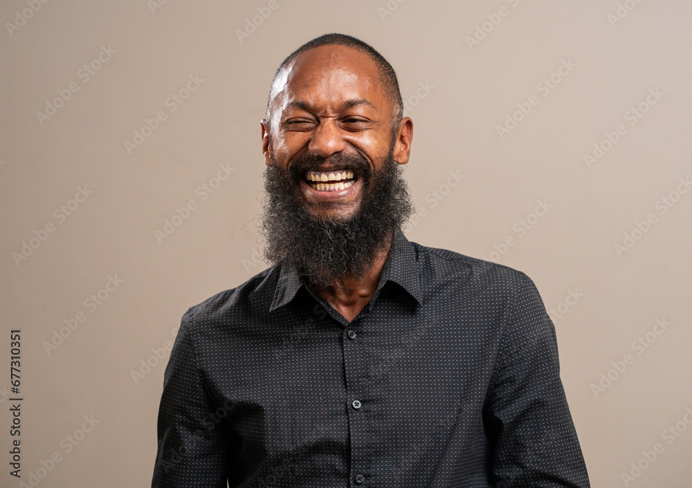 Bearded black man smiling on pastel background. Bearded black man smiling on pastel background.