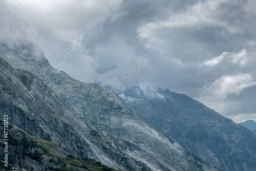 Fototapeta Naklejka Na Ścianę i Meble -  Peaks getting hidden by the clouds in the Alps