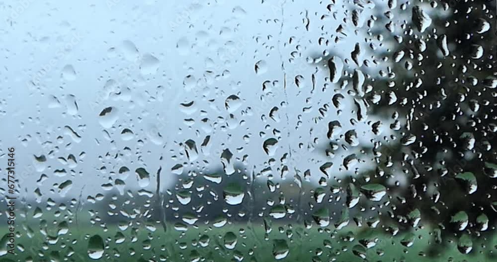 Raindrops on window pane and view of countryside field time lapse Raindrops on window pane and view of countryside field time lapse