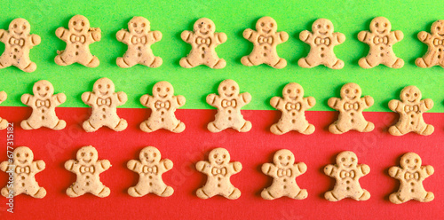 Mini gingerbread men cookies over green and red background.