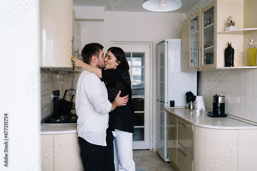 Happy couple hugging and kissing in kitchen