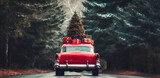 Red retro car with christmas tree and gift boxes on the top. Merry Christmas and a Happy New Year concept.