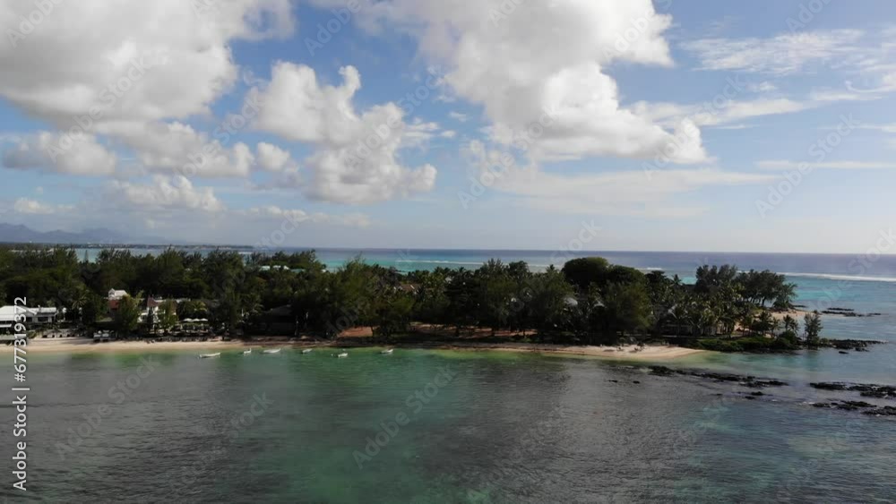 View of tropical island with reefs and calm waves with sandy tourist beach in Grand-Baie, Mauritius View of tropical island with reefs and calm waves with sandy tourist beach in Grand-Baie, Mauritius