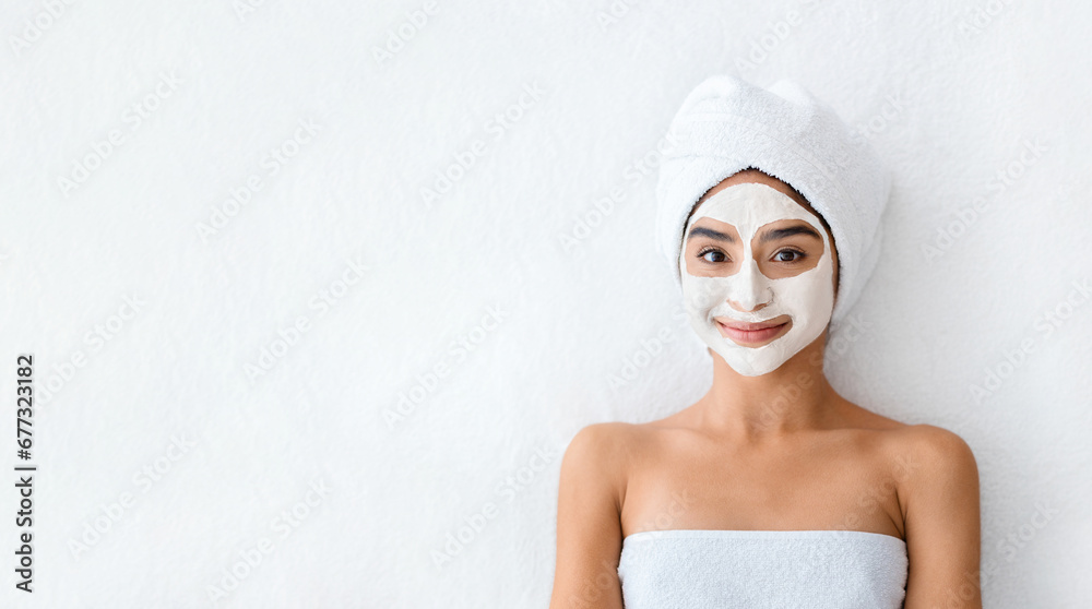 Young indian woman applying facial clay mask at spa Young indian woman applying facial clay mask at spa