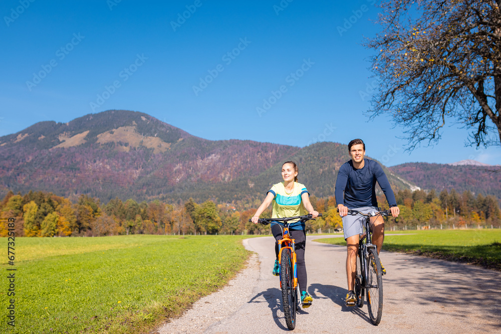 Cycling couple relaxing and enjoying a ride at the park in the autumn season. Recreation, leisure, and nature concepts. Cycling couple relaxing and enjoying a ride at the park in the autumn season. Recreation, leisure, and nature concepts.
