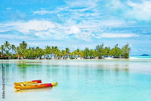 Brightly colored kayaks, an idyllic lagoon and a sand bar with palm trees sums up the tropical paradise of Aitutaki in the Cook Islands. photo