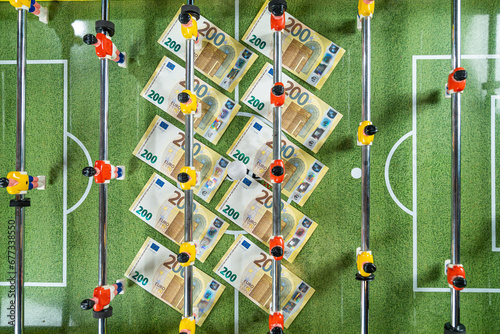 Table Soccer or Foosball Kicker Game, Top View on the 200 euro banknotes under the players figures, money rules sports