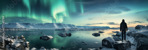 Daring hiker conquers icy cliff under the northern lights glow 