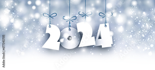 Horizontal winter light blue banner with 2024 white paper text with shadows. Blurred light particles, snowflakes and bokeh.