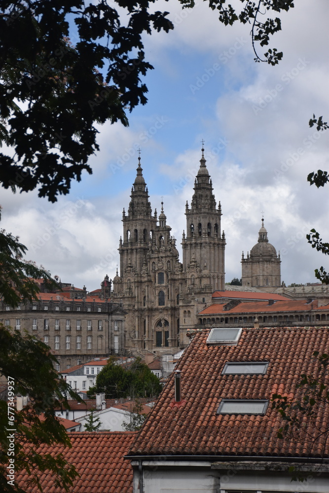 view of the cathedral of Santiago in Spain, blue sky with some clouds and red roofs of the surrounding houses.