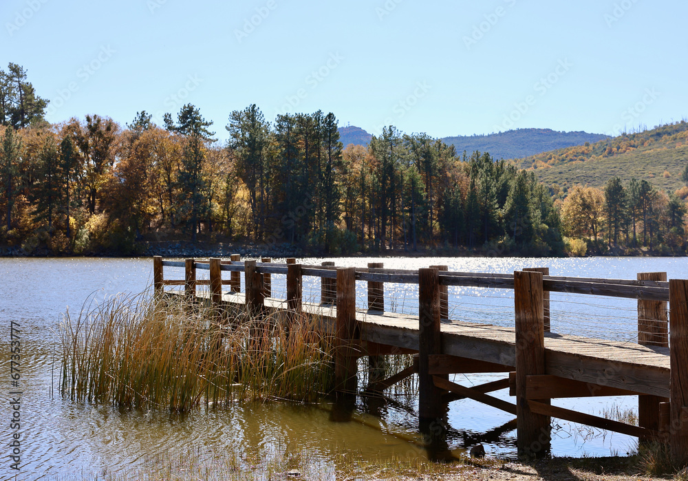 wood fishing dock leading out onto the lake