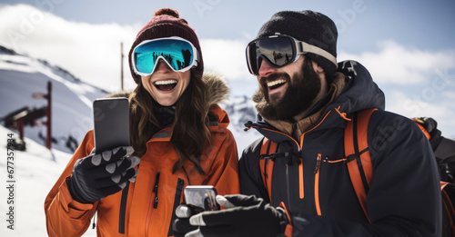 young male and female skiers and hold smartphone at ski station during winter