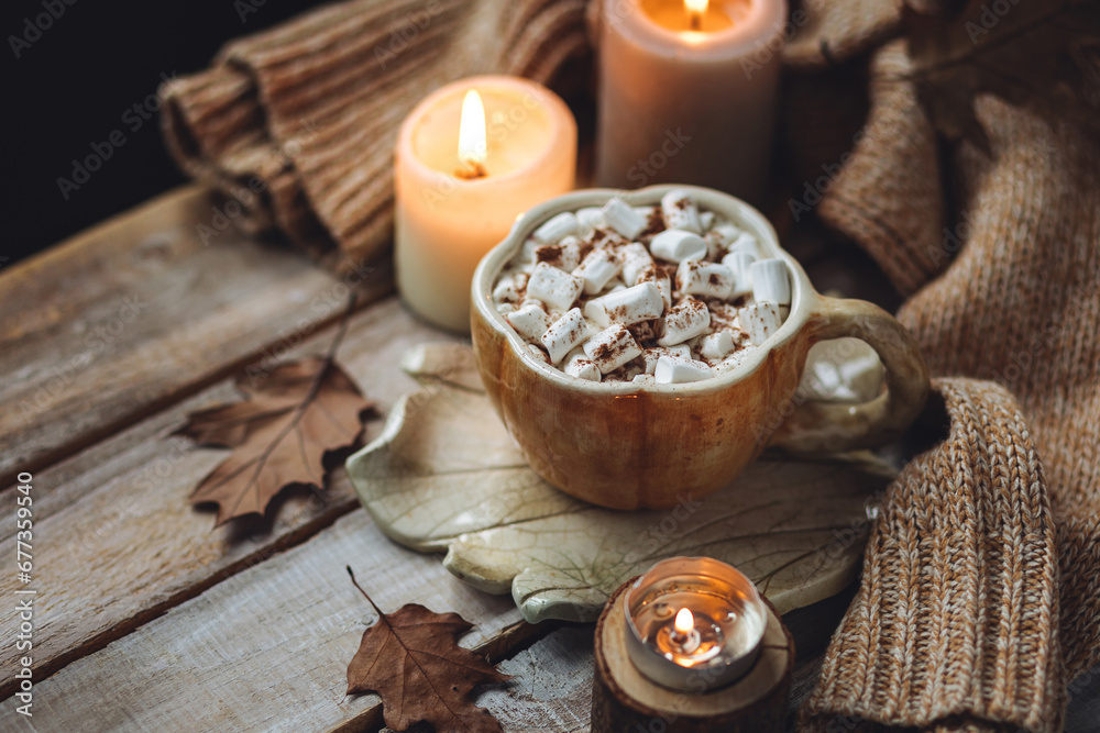 Spicy sweet fall hot drink: delicious pumpkin latte with cinnamon, marshmallow with salted caramel. Served in handmade artisan mug in shape of pumpkins, cozy home decor with candles, dry autumn leaves Spicy sweet fall hot drink: delicious pumpkin latte with cinnamon, marshmallow with salted caramel. Served in handmade artisan mug in shape of pumpkins, cozy home decor with candles, dry autumn leaves