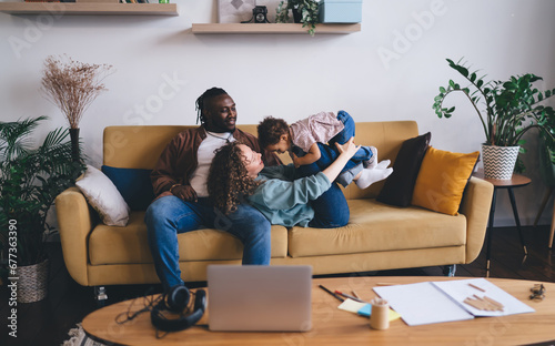 Happy family playing together over sofa in living room