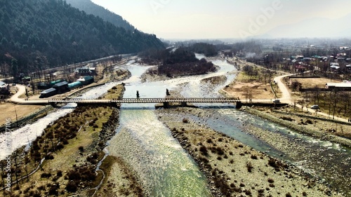 Drone view over a bridge over a River in Pahalgam, Kashmir, India with cloudy sky