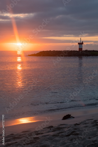 View of the Punta Carola Lighthouse and the beach during a reddish sunset, San Cristobal Island, Galapagos Islands Archipelago photo