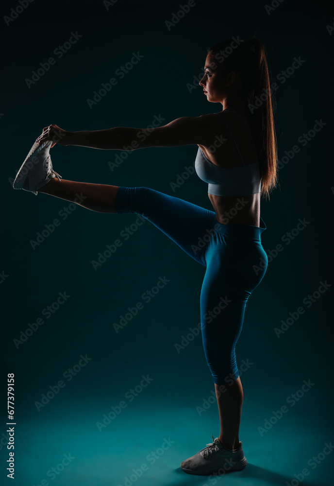 Confident Fit Woman Exercising in Dark Studio - Fitness Motivation