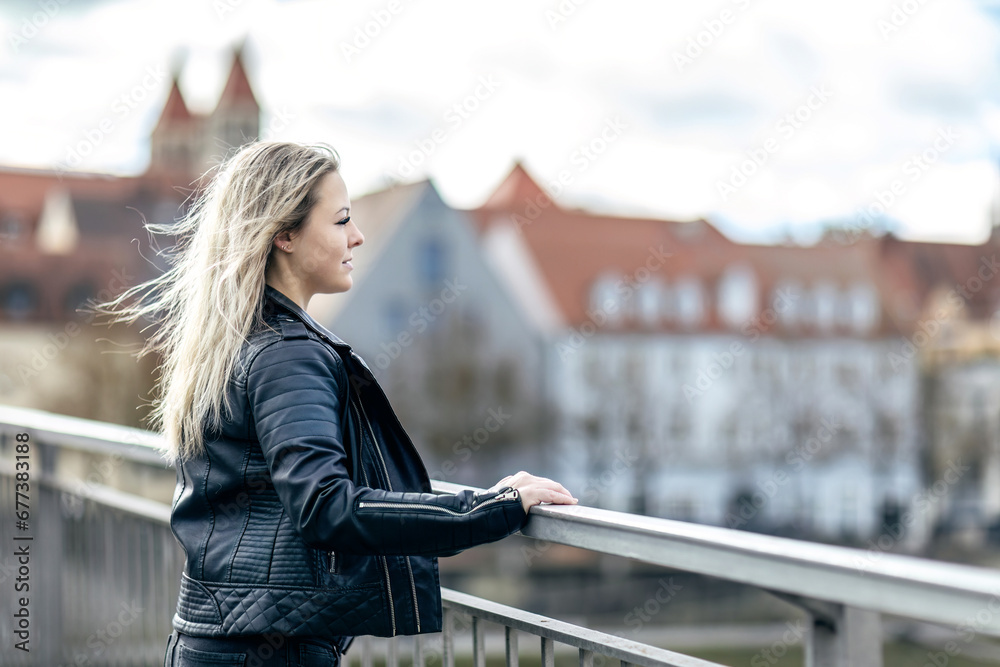A young blonde woman enjoying the view of a city