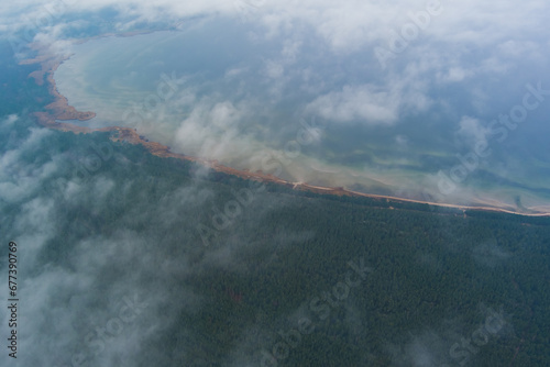 Photo from a high altitude, clouds over the forest and seashore in Kaberneeme. photo