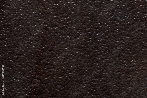 Dark textured background image resembling divoted or dimbled brown stone.