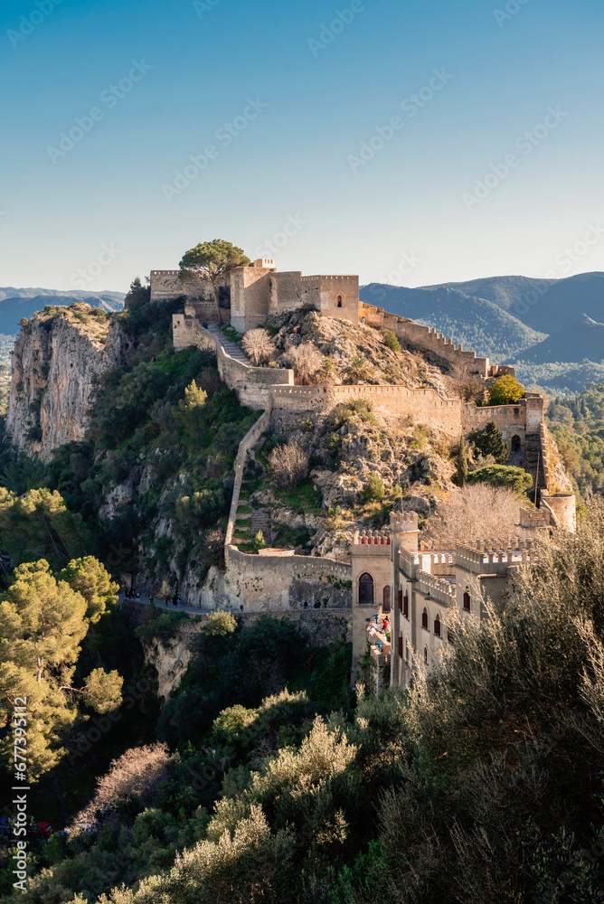 Walled fortress of Xativa, Spain, perched atop a rocky promontory in the golden light of dawn.