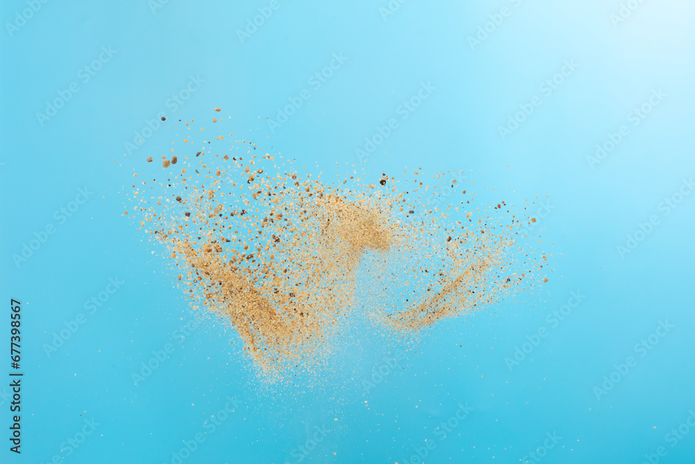 Big size Sand flying explosion, Golden grain wave explode. Abstract cloud fly. Yellow colored sand splash throwing in Air. Blue sky background Isolated, throwing freeze stop motion