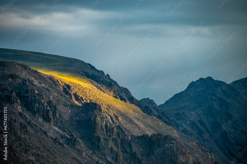 Sunlight Spills Over a Cliff In The Tundra Of Rocky Mountain