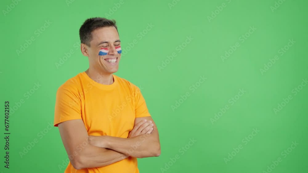 Happy man with dutch flag painted on face looking away Happy man with dutch flag painted on face looking away