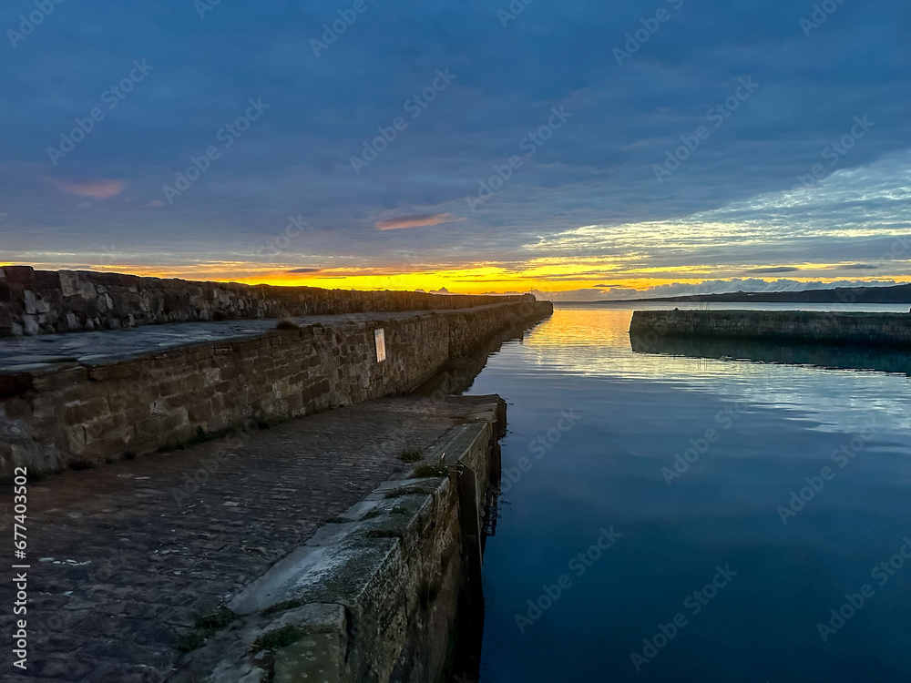 St Andrews, Scotland - September 22, 2023: Views of the buildings, vessels, breakwater and marina in St Andrews Scotland at sunrise
