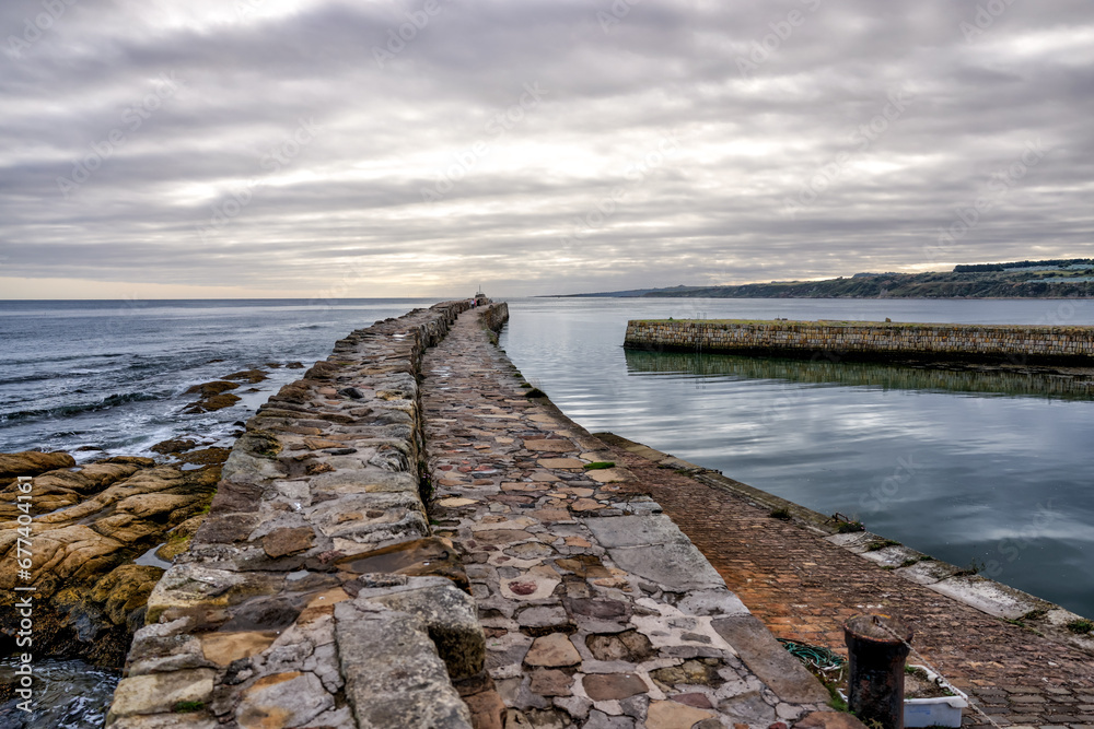 St Andrews, Scotland - September 22, 2023: Views of the buildings, vessels, breakwater and marina in St Andrews Scotland at sunrise
