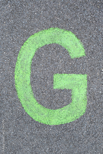 the Letter G are drawn with color paint on asphalt. a children's playground designed a creative display of the alphabet educational element learning space.