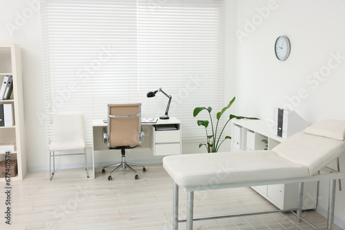 Modern medical office with doctor s workplace and examination table in clinic