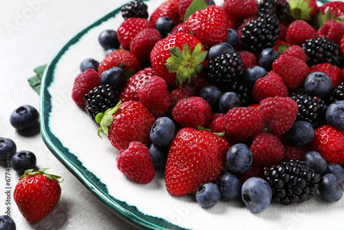 Different fresh ripe berries on light grey table  closeup