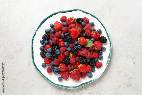 Different fresh ripe berries on light grey table, top view