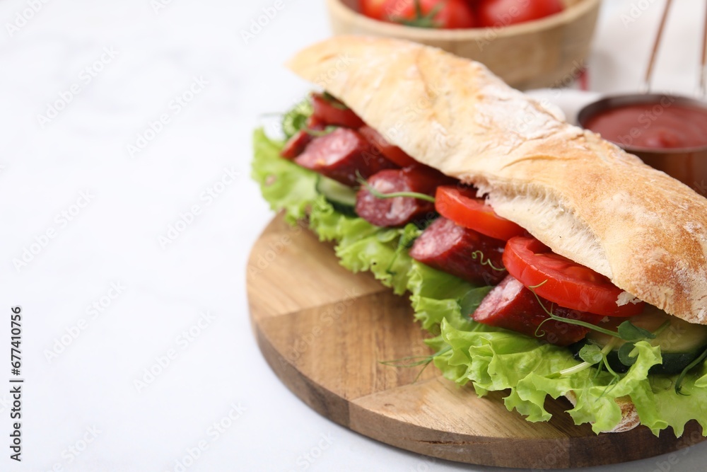 Obraz premium Delicious sandwich with sausages and vegetables on white table, closeup. Space for text