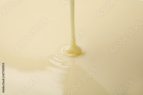 Closeup view of pouring condensed milk. Dairy product