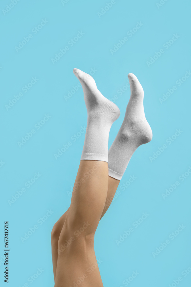 Woman in stylish white socks on light blue background, closeup Woman in stylish white socks on light blue background, closeup